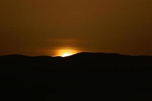 zonsopgang op de dode zee van achter de bergen in jordan foto