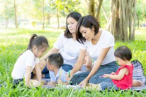 mooie jonge Aziatische ouder familieportret picknick in het park, kind of kinderen en moeder liefde gelukkig en vrolijk samen in de zomer in de tuin, lifestyle concept.