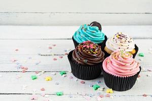 smakelijke kleurrijke cupcakes geïsoleerd op houten achtergrond. heerlijke cupcake foto
