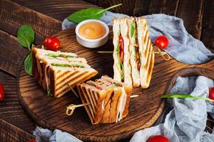 clubsandwich met ham, tomaat, kaas en spinazie. gegrilde panini foto