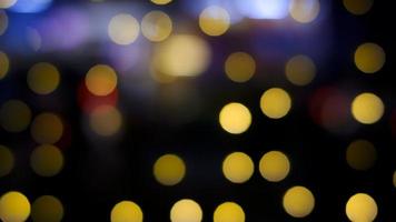 abstracte wazig veelkleurige hangende decoratieve lichten met bokeh op de achtergrond van de nachtstad foto