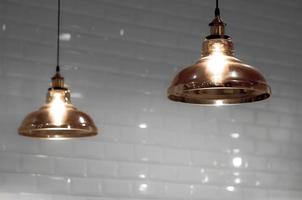 zachte focus van 2 vintage glazen plafondlampen in bronskleur met vage witte tegels muur achtergrond in huis interieur decoratie concept foto