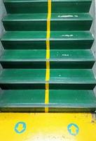 betonnen trappen zijn groen geverfd en er zijn gele pijlen die de weg naar boven en naar beneden aangeven, ideeën geven, regels. foto