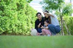 Aziatische familie met zowel vader, moeder als dochter die plezier hebben in de tuin van het huis foto