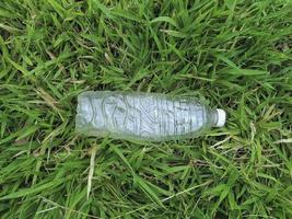 fles vers water op groen gras, bovenaanzicht foto