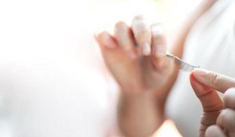 vrouwelijke hand die de wimper vasthoudt en aan haar oog vastmaakt. foto