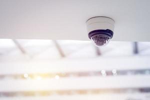 cctv-beveiligingscamera op wit plafond, intelligente camera's, video-opname, antidiefstalsysteem, bewaking. foto