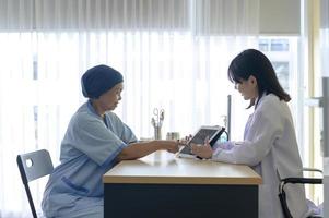 kankerpatiënt vrouw met hoofddoek na chemotherapie consultatie en bezoekende arts in het ziekenhuis.. foto