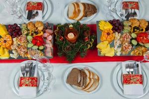 mooie feestelijke tafel geserveerd voor huwelijksfeest diner thuis of restaurant interieur. tafel vol eten in een restaurant. volledige ronde tafel. foto