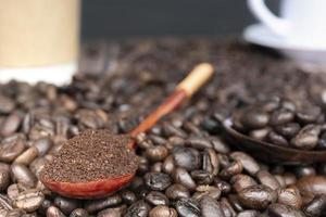 gebrande koffiebonen en koffiepoeder of gemalen koffie in houten lepel. foto