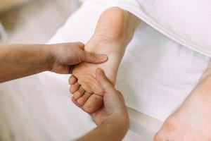 de masseur geeft een massage aan de vrouwelijke voeten in de spa. het concept van cosmetische procedures. foto