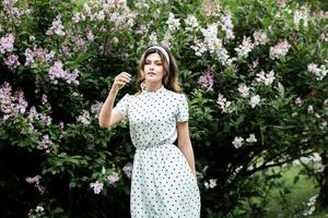 vrouwenportret met een haar dat in de wind beweegt. portret van jonge mooie Russische brunette meisje in zomer groen park. Europese blanke vrouw in jurk. foto