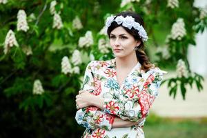 vrouwenportret met een haar dat in de wind beweegt. portret van jonge mooie Russische brunette meisje in zomer groen park. Europese blanke vrouw in jurk. foto