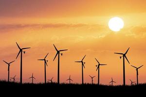 windturbines produceren 's avonds elektriciteit. zonsondergang, silhouet, windmolens, schone energie in de avond. hernieuwbaar concept alternatief en schone en windenergie foto