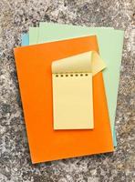 open gele notitieblok op gekleurd papier
