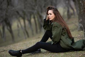 afbeelding van jonge mooie vrouw die regenjas draagt bij koud weer. denker europees meisje in de lente natuur. foto