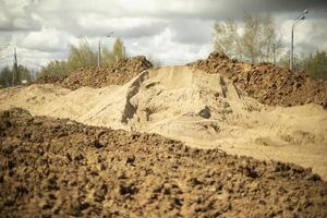 uitgegraven grond. uitgegraven aarde. bouwdetails. het creëren van een dijk voor de weg. foto