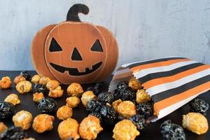 Halloween-popcorn die uit oranje en zwarte zak morst foto