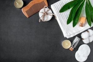 natuurlijke lichaamsverzorging cosmetica op concrete achtergrond. spa-accessoires, handdoek, haarborstel, etherische olie. foto