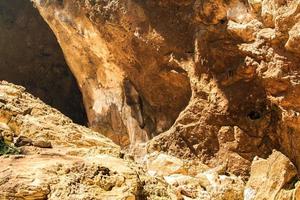 granieten kalksteen in de grot, maar het zonlicht schijnt fel en toont de concave rondingen en vormen van de van nature prachtige rotsen van stalagmieten en stalactieten. foto