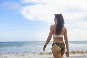 jonge mooie vrouw in bikini genieten en ontspannen op het strand, zomer, vakantie, vakantie, levensstijl concept. foto