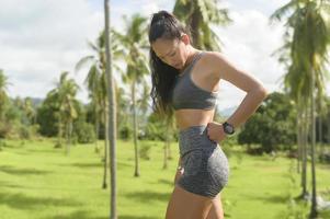 portret van een mooie fitte vrouw die sportkleding draagt in een tropisch park, een gezondheids- en sportconcept. foto