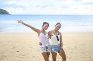 twee vrouwen genieten en ontspannen op het strand, zomer, vakantie, vakantie. foto