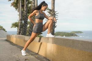 portret van mooie fit vrouw in sportkleding op de bergtop aan zee, gezondheid en reizen concept. foto