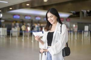 jonge vrouwelijke reiziger die koffers draagt op de internationale luchthaven, reizen, vakanties en reisconcept. foto