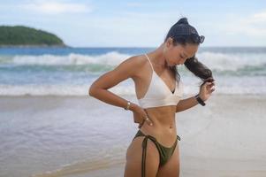 jonge mooie vrouw in bikini genieten en ontspannen op het strand, zomer, vakantie, vakantie, levensstijl concept. foto