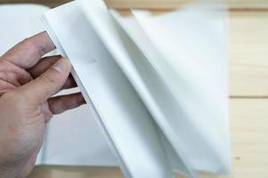 man hand open de witte lege notebook op de houten tafel. foto