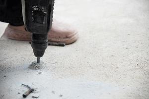 bouwvakker doet zijn werk - boren van betonnen vloer foto