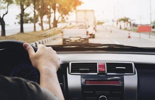 close-up van een man die een auto bestuurt met één hand, gevaarlijk gedrag foto