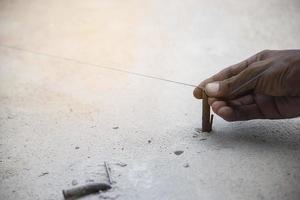 werkman stelt niveau in voor het storten van betonnen vloeren - man aan het werk in bouwplaatsconcept foto