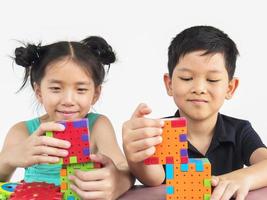 Aziatische kinderen spelen een creatief puzzelspel met plastic blokken om hun fysieke en mentale vaardigheden te oefenen foto