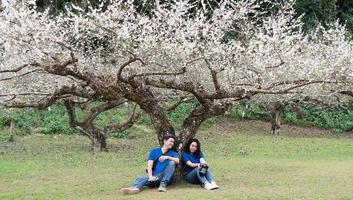 Aziatisch stel dat gelukkig foto's maakt in de prachtige perziktuin van de natuur in doi ang khang, chiangmai thailand foto