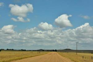 landelijke en afgelegen onverharde weg door landbouwgrond foto