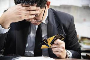 zakenman met creditcards die serieus nadenken over het probleem van de betalingslening - mensen met een persoonlijk financieel crisisconcept foto