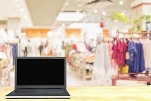 laptop op houten tafel over wazige superstore-achtergrond foto