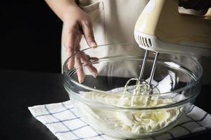 dame die cake maakt die room zet met behulp van spatel - zelfgemaakte bakkerij kookconcept foto