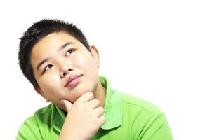 Aziatische 13 jaar oude jongen die denkende uitdrukking maakt die over witte achtergrond wordt geïsoleerd foto