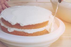 vintage foto van het met de hand zetten van boterroomcake met spatel