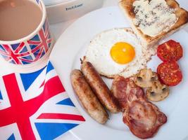 gebakken ontbijt met kopje thee, toast en Britse vlag foto