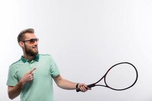 knappe jonge man in poloshirt met tennisracket foto