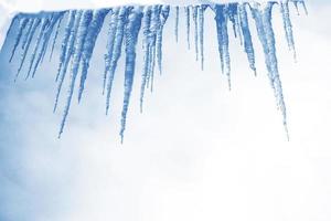 witte ijspegels tegen de blauwe winterhemel. foto