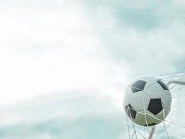 voetbal in doelnet met blauwe hemelachtergrond foto