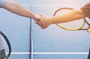 tennisspelers die de hand schudden voor de wedstrijd op de tennisbaan foto