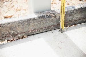 bouwvakker doet zijn werk - met behulp van meetlint voorbereiden om betonnen vloer te gieten foto