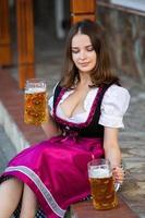 sexy Russische vrouw in Beierse jurk met bierpullen. foto