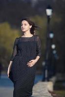 vrouwenportret met een haar dat in de wind beweegt. close-up portret van jonge mooie Russische brunette meisje op zomer groen park. Europese blanke vrouw in jurk. foto